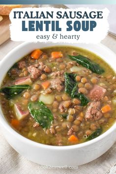 italian sausage lentil soup in a white bowl with spinach leaves and carrots