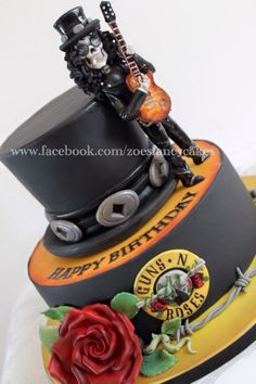 a birthday cake with a guitar and skull on it's top tier is shown