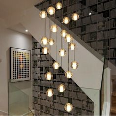 a bunch of lights hanging from the side of a stair case