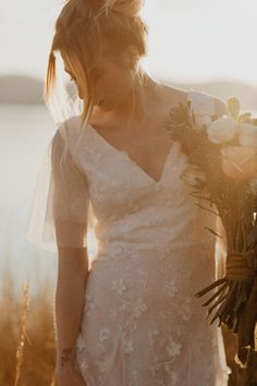 a woman in a wedding dress holding flowers