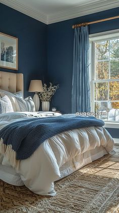 a bedroom with blue walls and white bedding