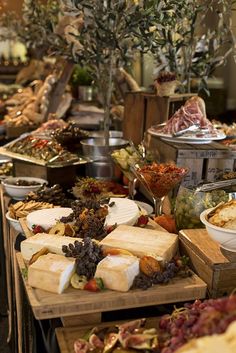 an assortment of cheeses and other foods on display