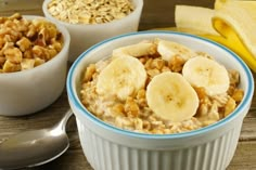 two bowls filled with oatmeal and bananas on top of a wooden table