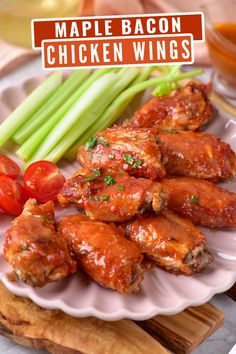 a plate with chicken wings, celery and tomatoes