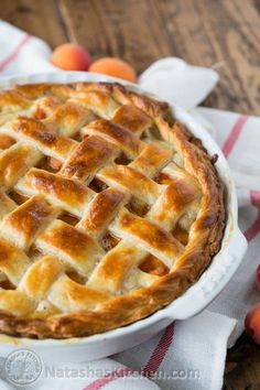 a pie sitting on top of a table next to peaches