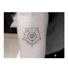 a black and white photo of a flower tattoo on the right leg, with an eyeball in the center