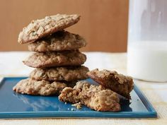 a stack of cookies sitting on top of a blue plate next to a glass of milk