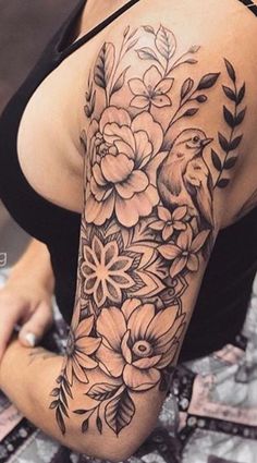 a woman's arm with flowers and birds tattoo on her left arm, in black and white