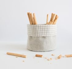 a small basket with wooden sticks sticking out of it