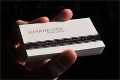 a person holding up a business card in their hand