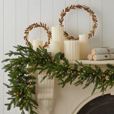 a mantle with candles and wreaths on it