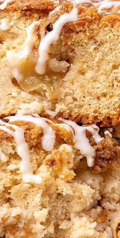 slices of cake with white icing sitting on top of each other next to some pecans