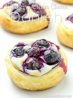 some blueberry donuts are sitting on a white surface