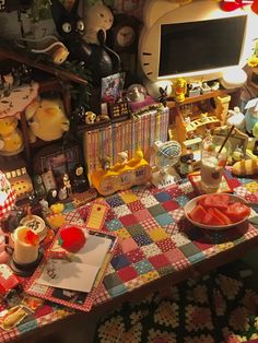 a table topped with lots of stuffed animals and other items next to a computer monitor