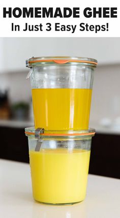 two glass containers filled with yellow liquid sitting on top of a table