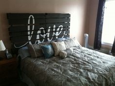 a bed made out of pallet wood with the word love spelled on it's headboard