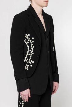 Comme des Garçons Homme Plus presents their embellished blazer for the Fall/Winter 2024 collection, showcasing the brand's innovative approach to tailoring. This blazer features notched lapels and a distinctive layered construction. Button embellishments along the outseams add a unique detail, embodying the brand's avant-garde aesthetic. Tailored Embellished Outerwear With Notch Lapel, Designer Evening Blazer With Buttons, Tailored Black Embellished Blazer, Tailored Embellished Blazer For Work, Designer Tailored Embellished Blazer, Designer Embellished Tailored Blazer, Designer Tailored Embellished Outerwear, Tailored Party Blazer With Buttons, Winter Workwear Embellished Blazer