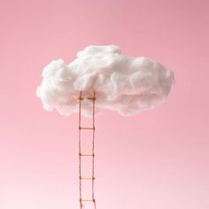 there is a ladder to the cloud on top of a pink wall and it's made out of wood