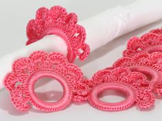 pink crocheted doily on top of a white napkin holder next to a roll of tissue paper