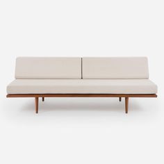 a white couch sitting on top of a wooden frame