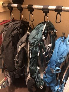 several backpacks are hanging on the wall