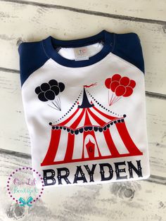 a white and blue shirt with a circus tent on the front that says brayden