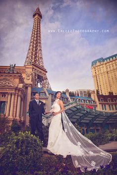 a newly married couple standing in front of the eiffel tower