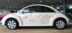 a white car parked in front of a building with hello kitty decals on it