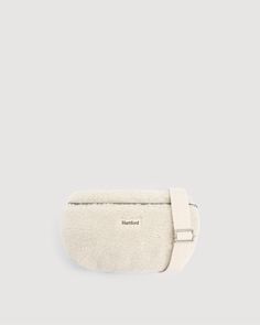 Women's sherpa fanny pack with off-white Hartford label on the front. Zipper closure and adjustable strap with an adjustment buckle. Lined with exclusive 'Zebra' print interior.