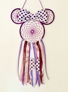 a purple and white mickey mouse dream catcher hanging from a wall with polka dots on it