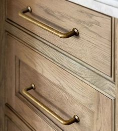 a wooden dresser with brass handles and knobs on it's drawers in a bathroom