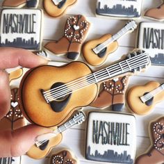 a person is holding a cookie shaped like a ukulele and playing the guitar