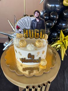 a birthday cake with an image of a man on top and gold decorations around it