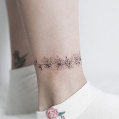 a woman's foot with a flower tattoo on it