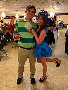 a man and woman dressed up in costumes posing for a photo at an event together