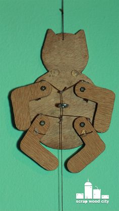 a wooden cutout of a teddy bear on a green background