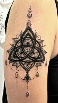 the back of a woman's thigh with an intricate tattoo design on her leg