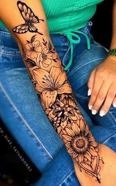 a woman's arm with flowers and butterfly tattoos on her left arm, sitting in a chair