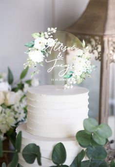 a wedding cake with white flowers and greenery