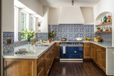 a blue and white kitchen with wooden cabinets