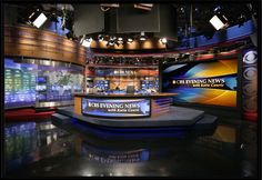 an empty news studio with two television sets