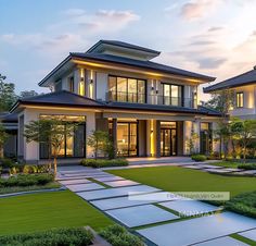 a large house with lots of windows and landscaping in front of it at dusk time