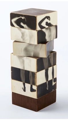 a stack of three wooden blocks with black and white images on them, each depicting a woman doing yoga