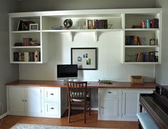 a home office with built in bookshelves and desk