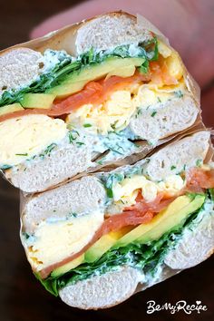 two sandwiches with eggs, tomatoes and avocado on them sitting on a table