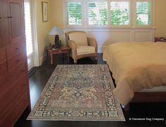 a bed room with a neatly made bed and a rug