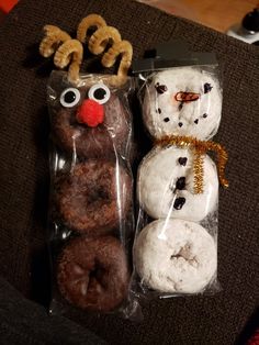 three doughnuts are wrapped in cellophane and decorated to look like snowmen