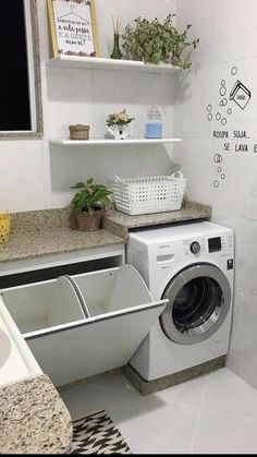 a washer and dryer sitting in a bathroom next to a window with plants on it