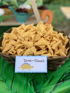 a bowl filled with yellow cheetos sitting on top of green grass next to a sign