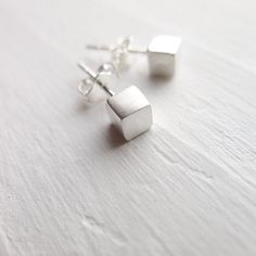 These earrings are perfectly petite and perfectly precious for every day wear. They are feature sterling silver brushed cubes on sterling silver posts. Sterling silver ear nuts are included. . { m e a s u r e m e n t s } . ~4mm each side . { o p t i o n s } . Other Post Earring Styles: https://www.etsy.com/shop/CamileeDesigns?section_id=10245147&ref=shopsection_leftnav_3 . { p a c k a g i n g } . Your jewelry will arrive in a cute snap box - perfect for giving or keeping for yourself. . { s Tiny Minimalist Sterling Silver Earrings, Tiny Modern Earrings For Gift, Modern Tiny Earrings For Gift, Sterling Silver Simple Design Earrings For Gift, Simple Sterling Silver Earrings As Gift, Simple Small Silver Earrings, Minimalist Silver Earrings For Gift, Minimalist Hypoallergenic Earrings For Gift, Cube Earrings